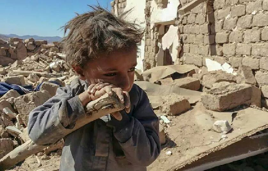 صورة لطفل على أنقاض منزل أسرته الذي فجرته مليشيا الحوثي في أرحب 