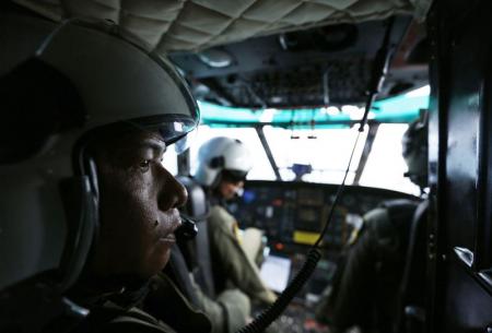 جنود اندونيسيون داخل مروحية خلال البحث عن حطام الطائرة المنكوبة يوم الأربعاء